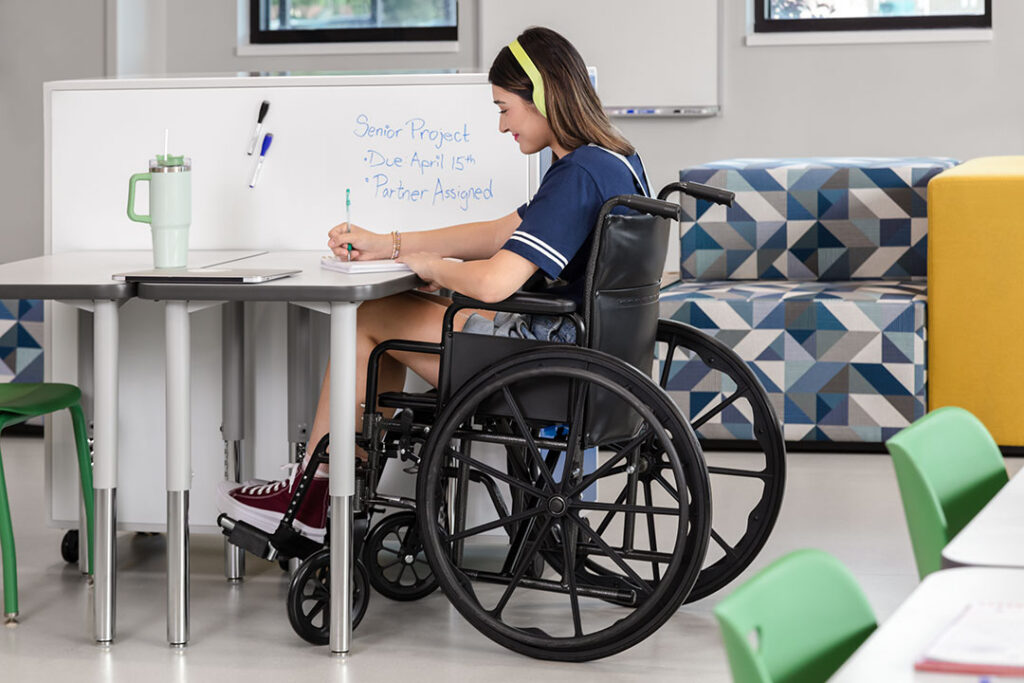 Student in a wheelchair positioned comfortably at a wheelchair-accessible desk